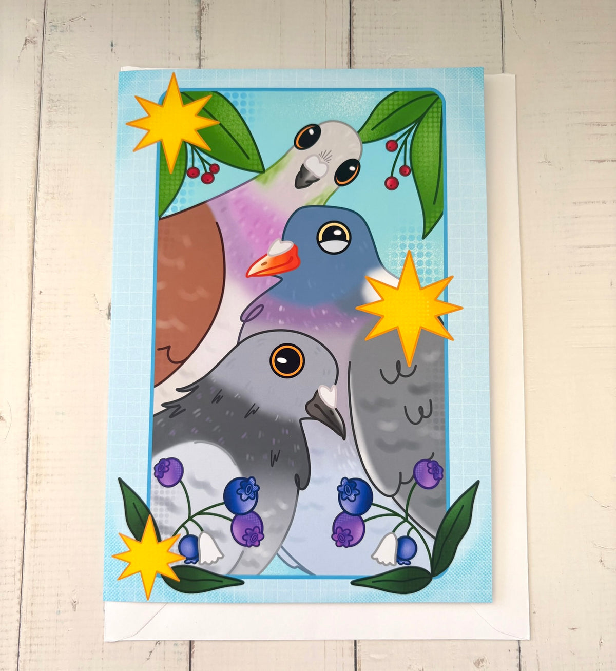 Trio Of Pigeons Greetings Card flat with envelope showing three stacked pigeons with berries and stars