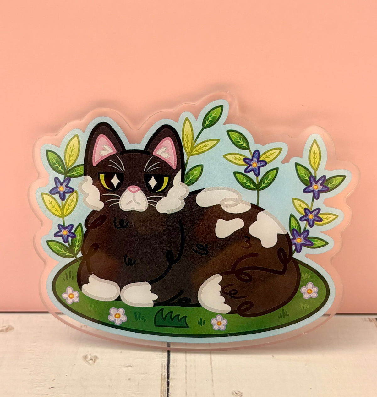 Cozy Garden Cat Pin - finished version featuring a tuxedo cat loafing in a garden with purple flowers