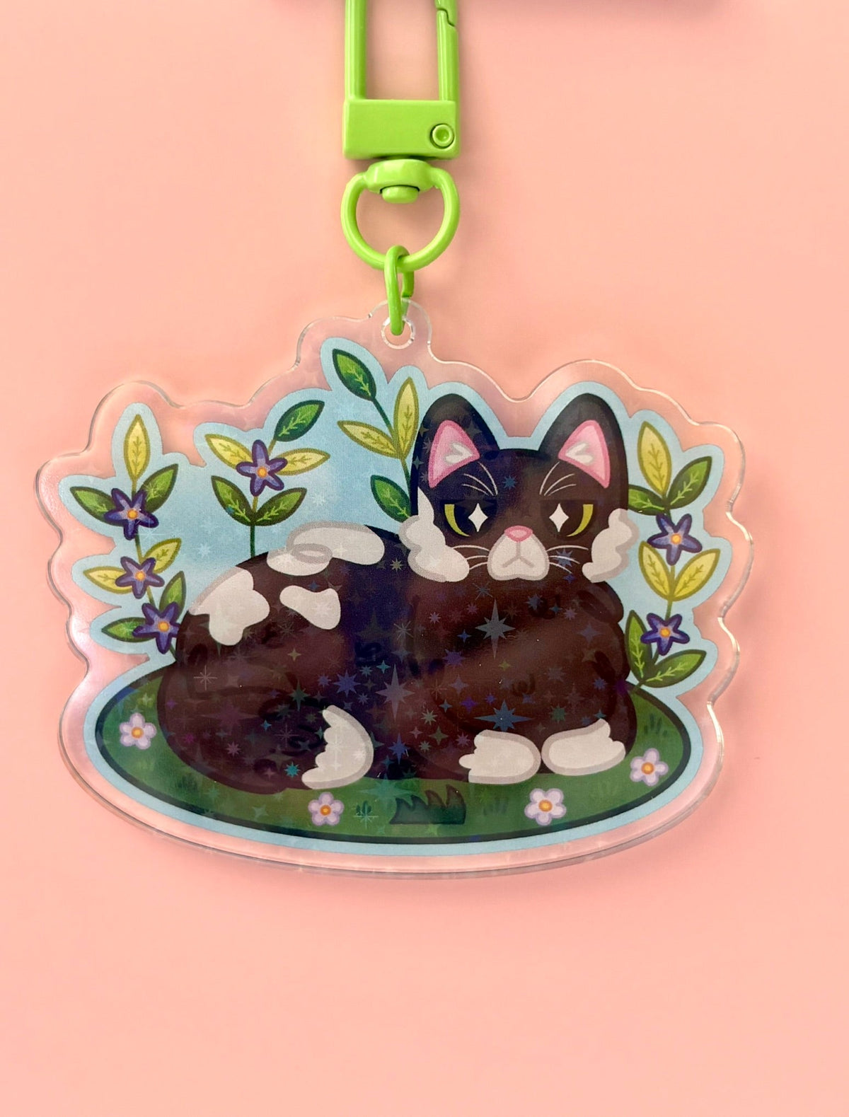 Garden Cat Holographic Keyring - tuxedo cat surrounded by flowers and leaves on a holographic acrylic charm