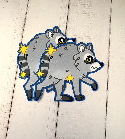 Jimothy Raccoon Sticker - two stickers showing a chunky raccoon with golden sparkle stars and blue outline